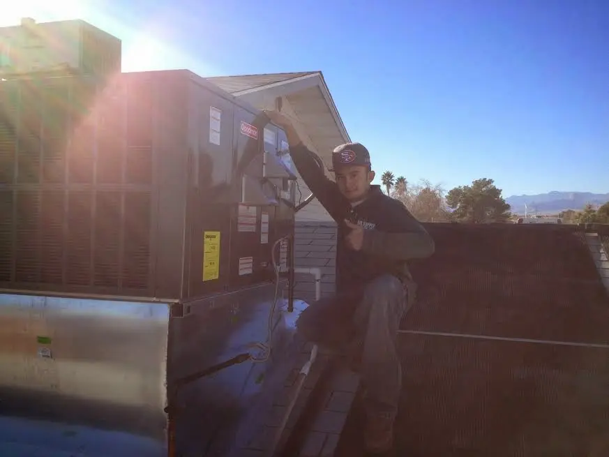 HVAC technician performing HVAC Inspection on a rooftop unit in Edgartown